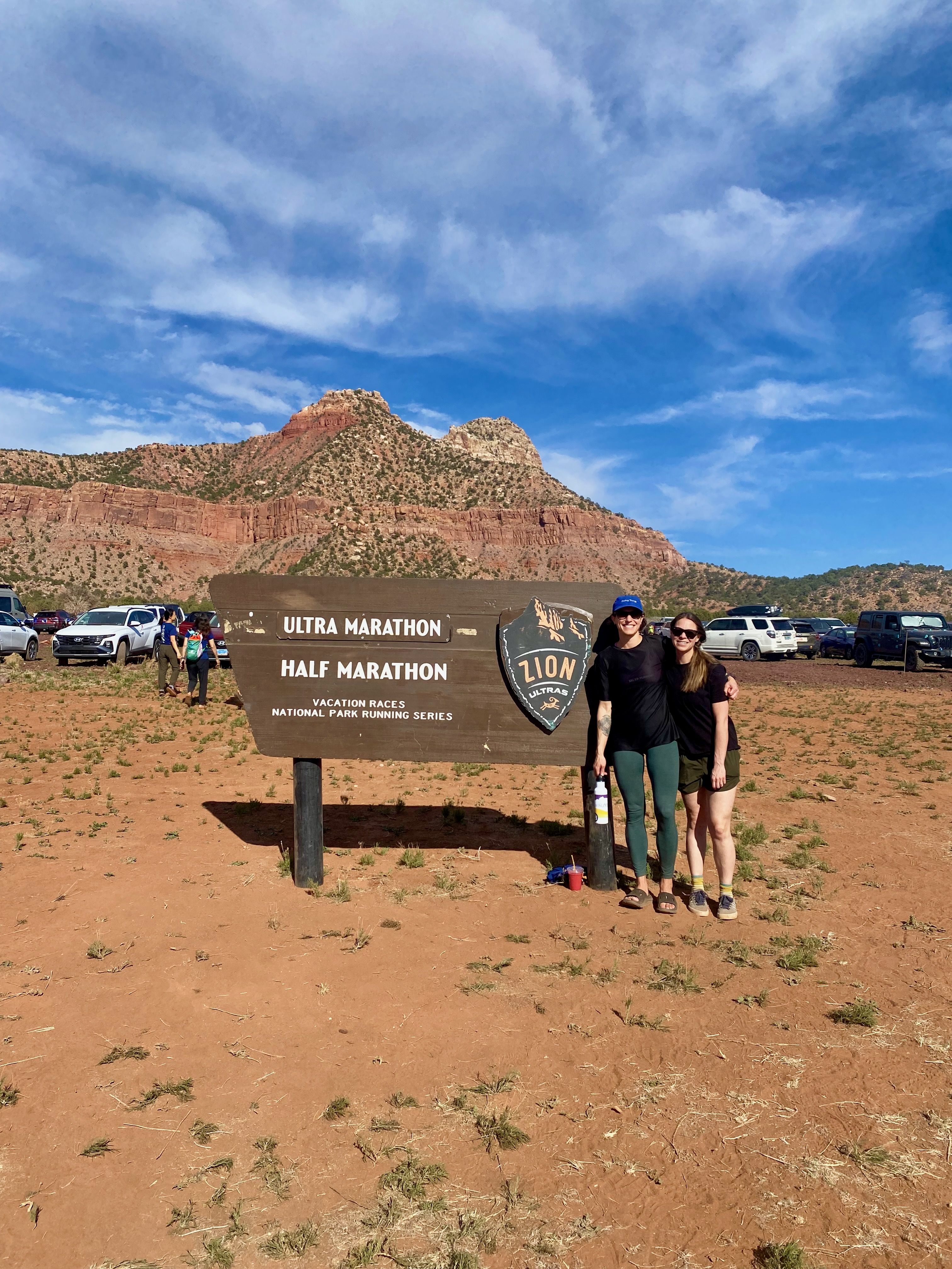 Friends hugging in front of sign for zion ultra marathon